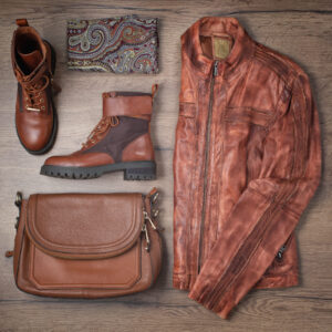 Leather jacket, scarf, bag and boots. Overhead view of women's casual or stylish outfit. Flat lay, top view. Women clothes.